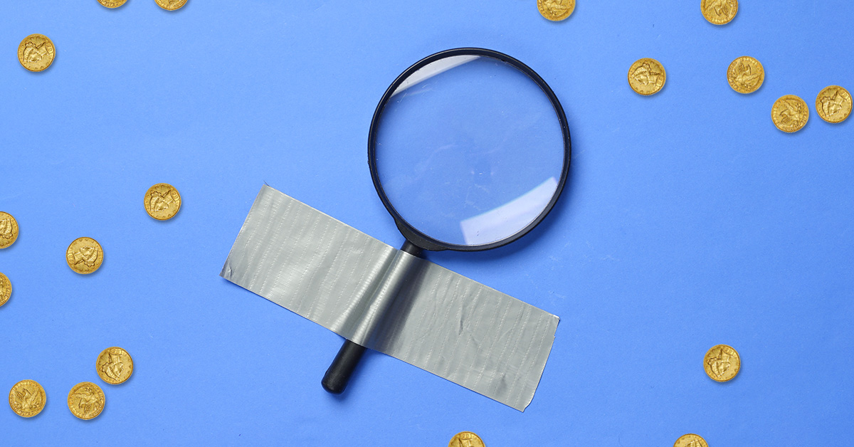 magnifying glass surrounded by coins