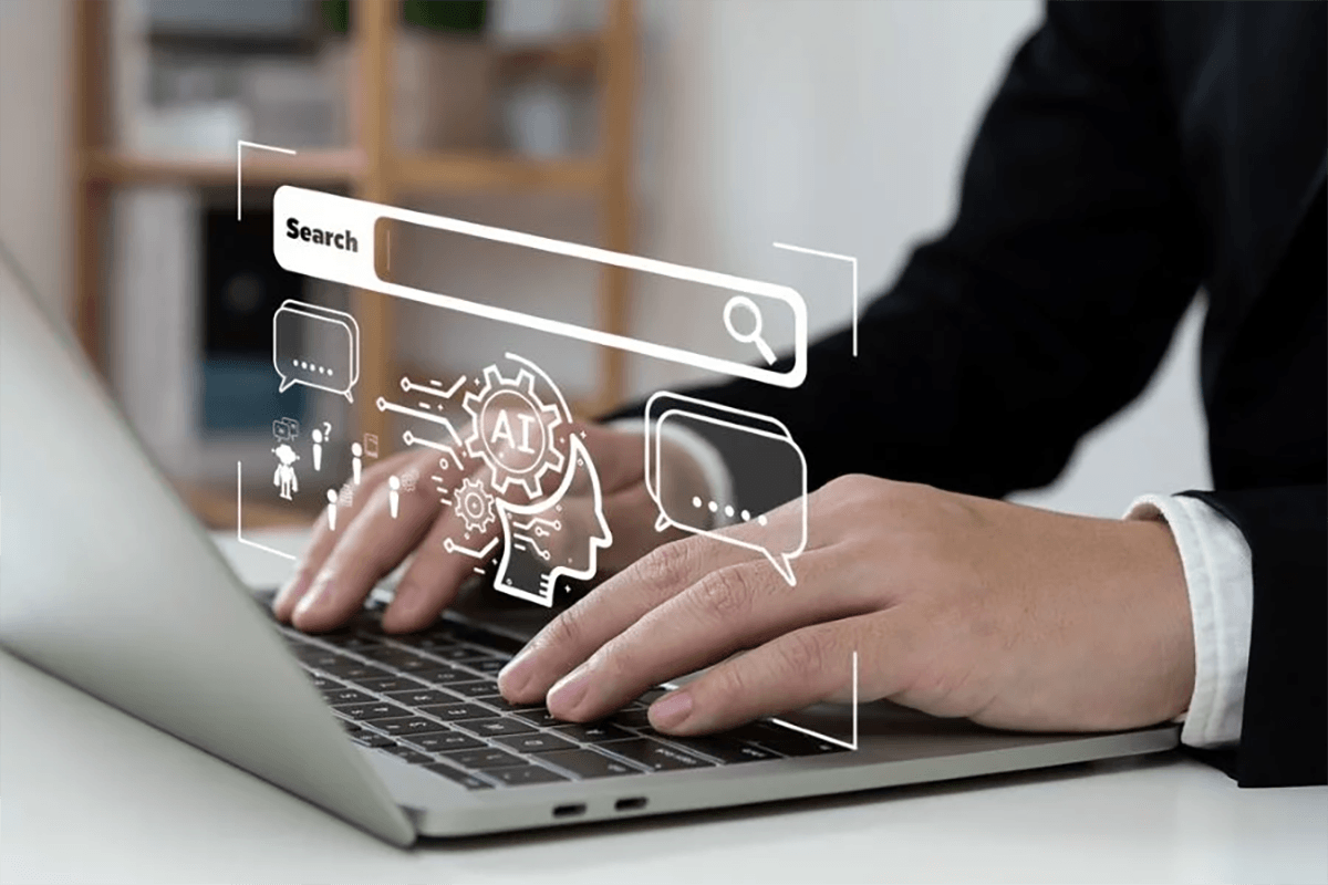 Hands typing on a laptop with AI search icons