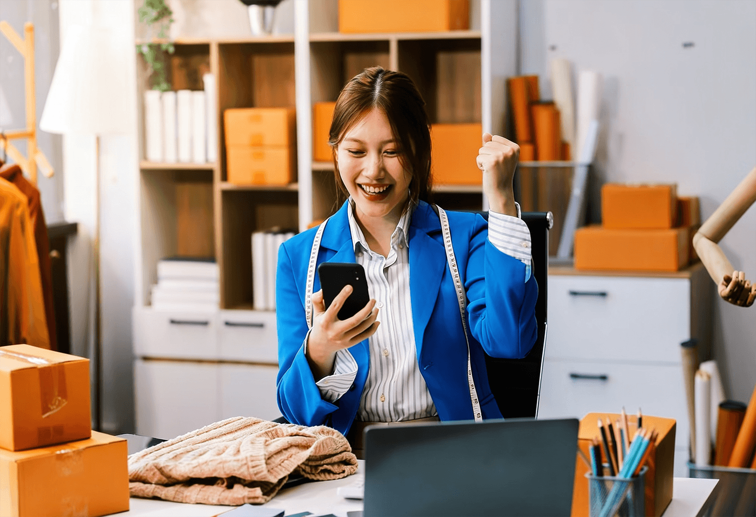 Business owner in her office, celebrating new orders