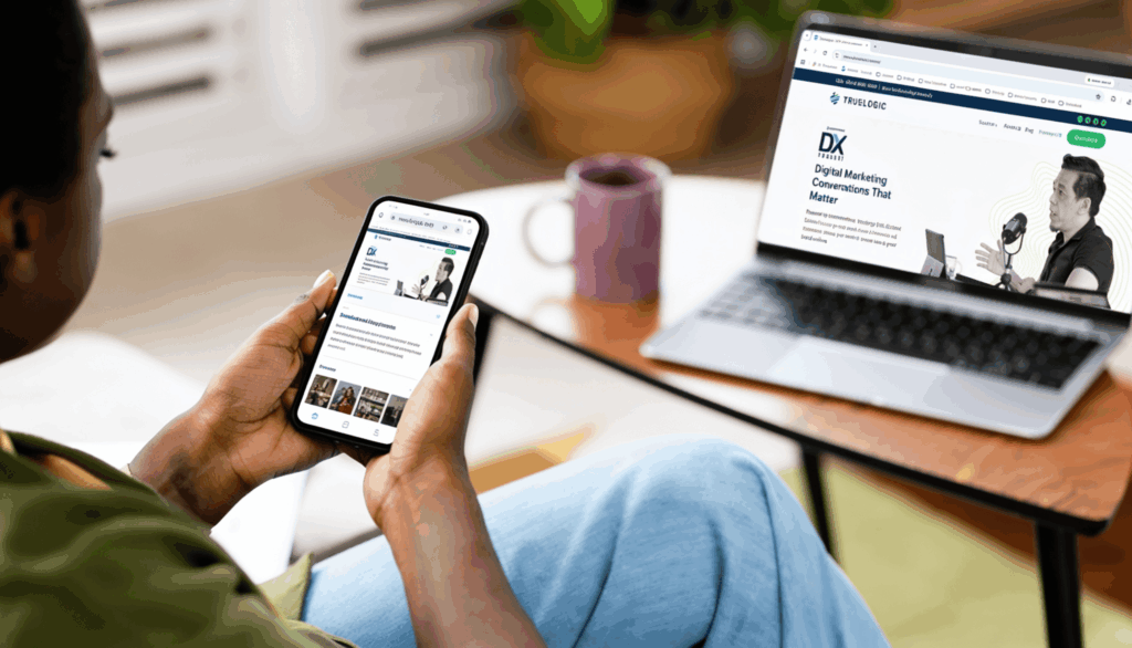 Woman looking at a podcast about digital marketing on her phone and laptop